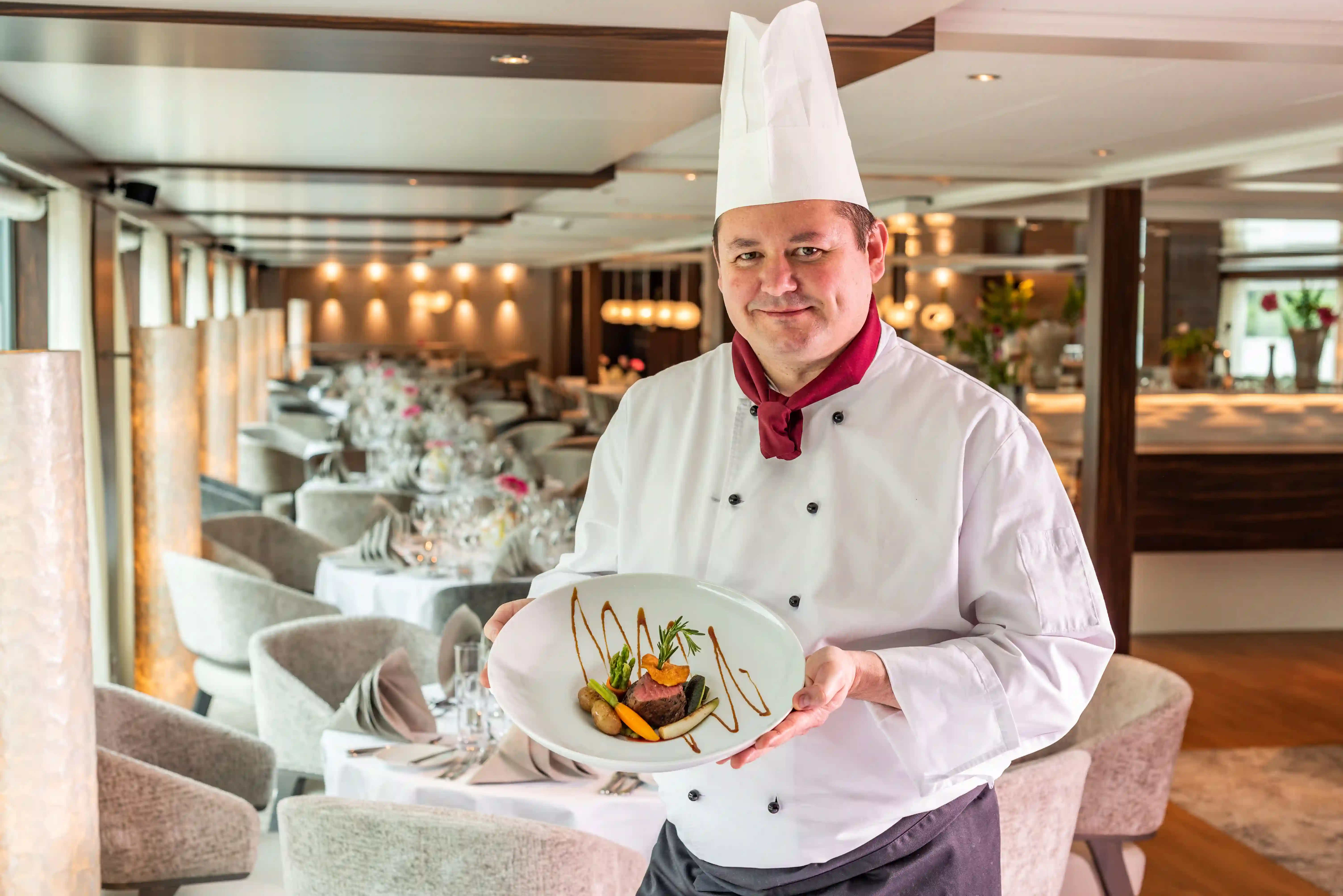 Küchenchef des AMADEUS Star präsentiert ein raffiniert angerichtetes Gourmetgericht