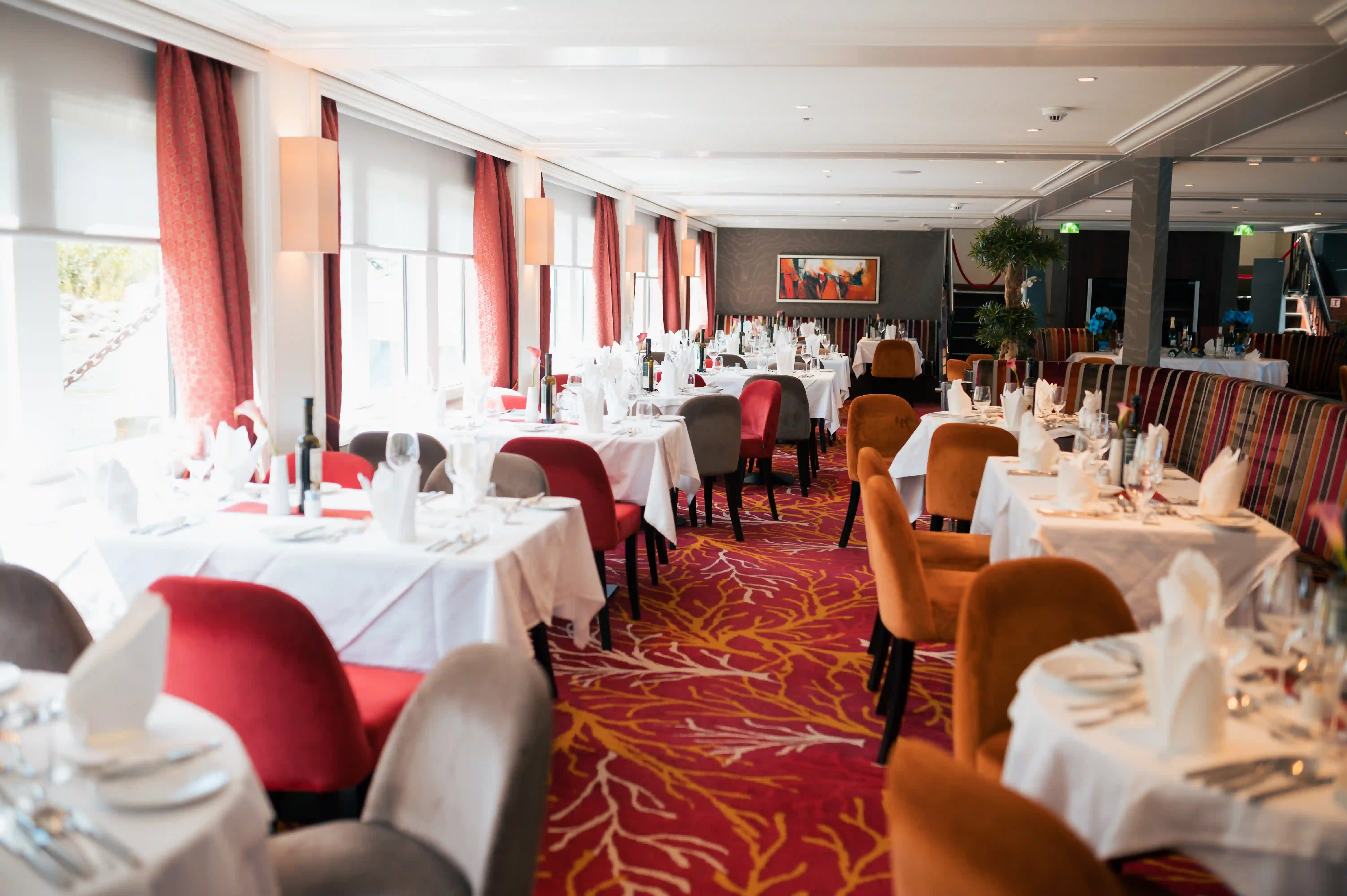 Restaurant panoramique du MS Charles Dickens avec tables élégamment dressées.