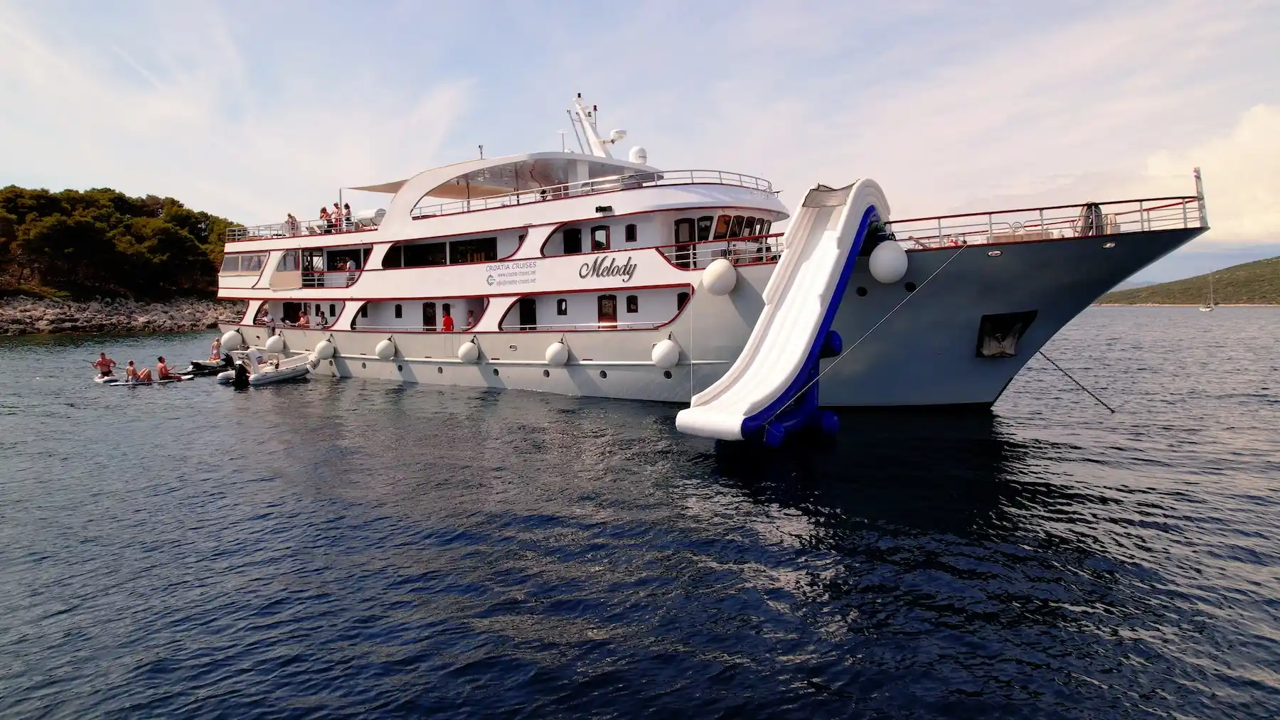 Kreuzfahrtschiff vor Anker mit Wasserrutsche und Badeplattform
