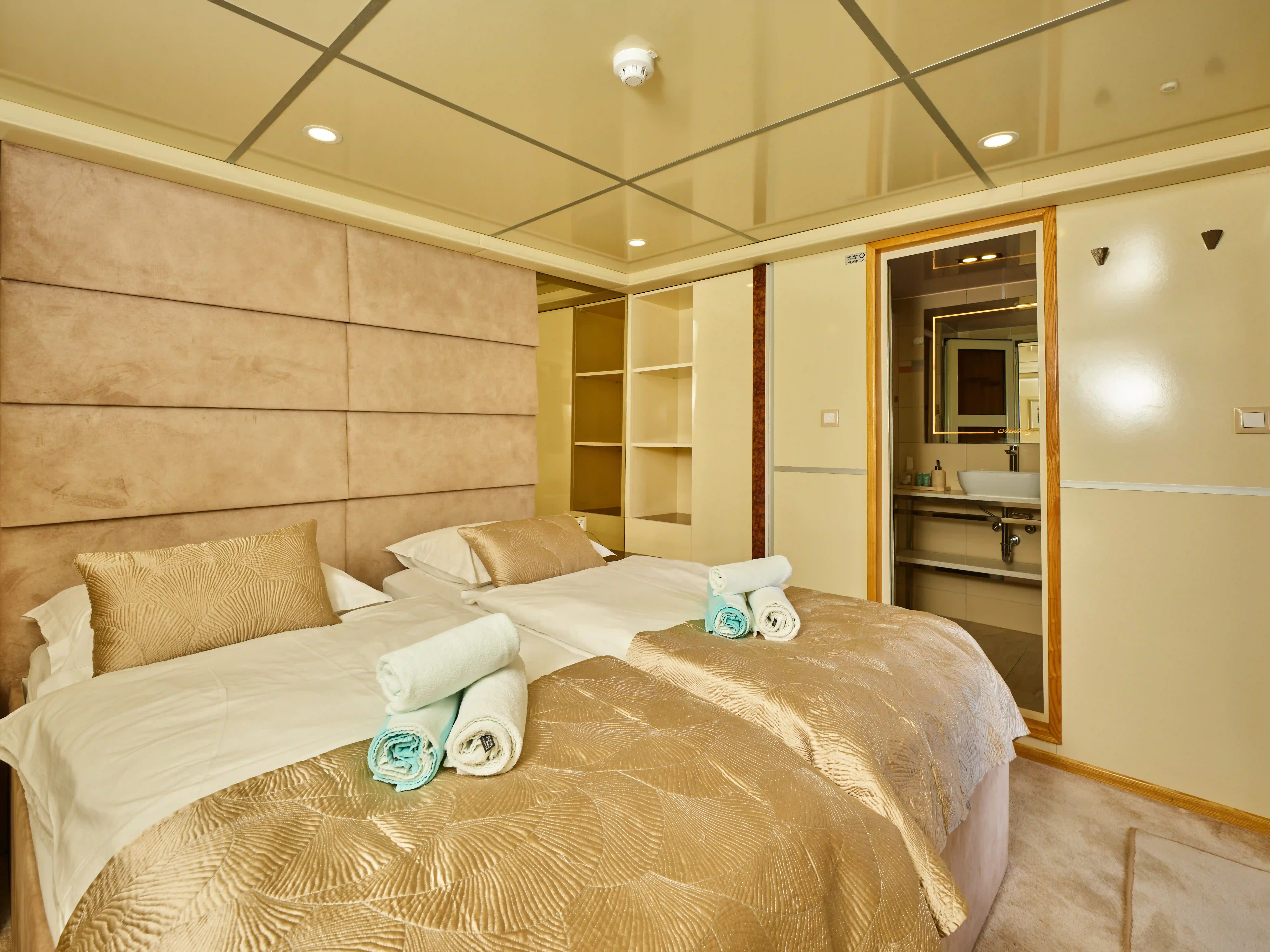 Elegante Kabine eines Kreuzfahrtschiffes mit zwei Betten und Bad