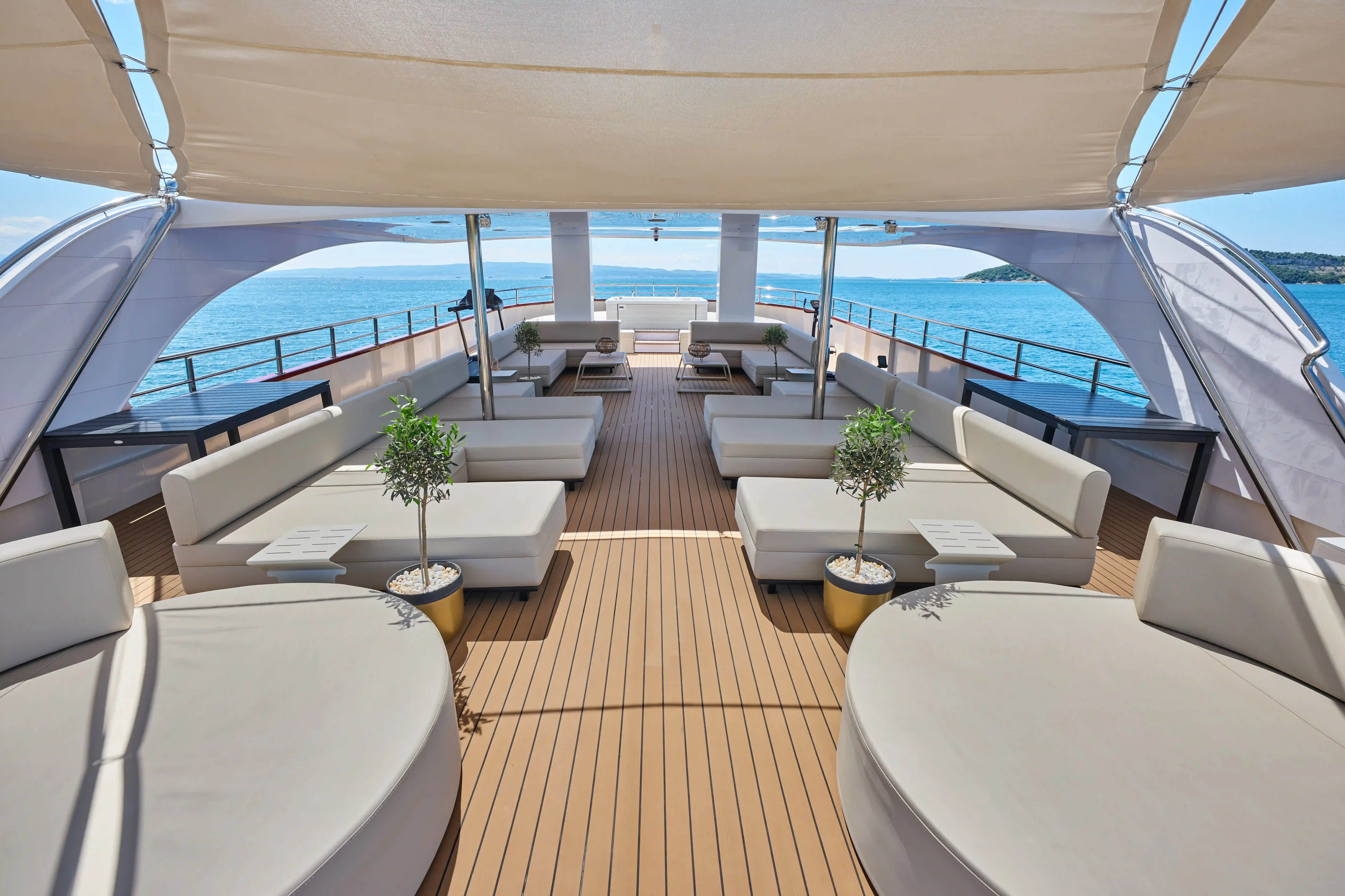 Sonnendeck eines Kreuzfahrtschiffes mit Lounge-Möbeln und Blick aufs Meer