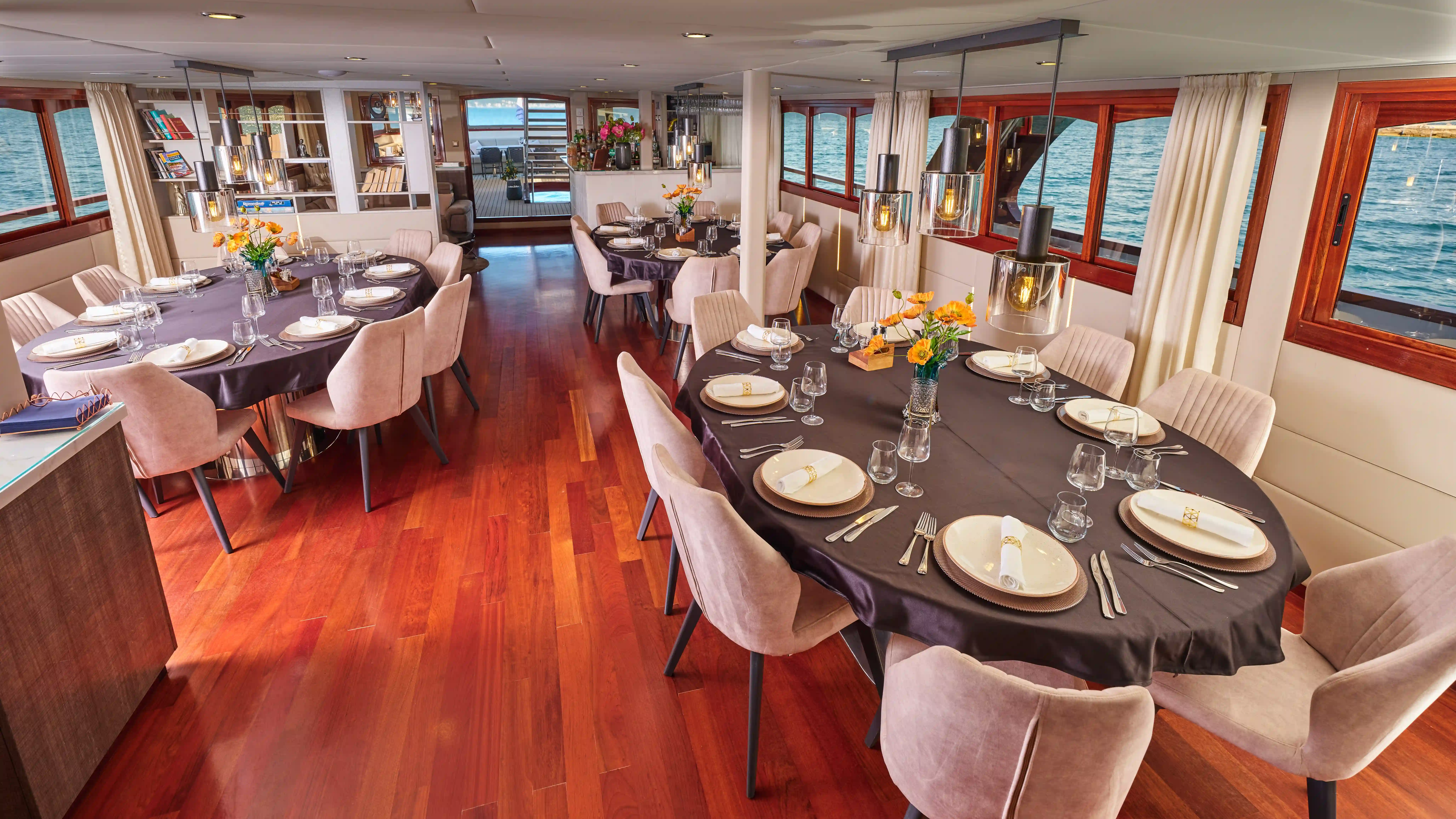 Restaurant an Bord eines Kreuzfahrtschiffes mit gedeckten Tischen und Meerblick