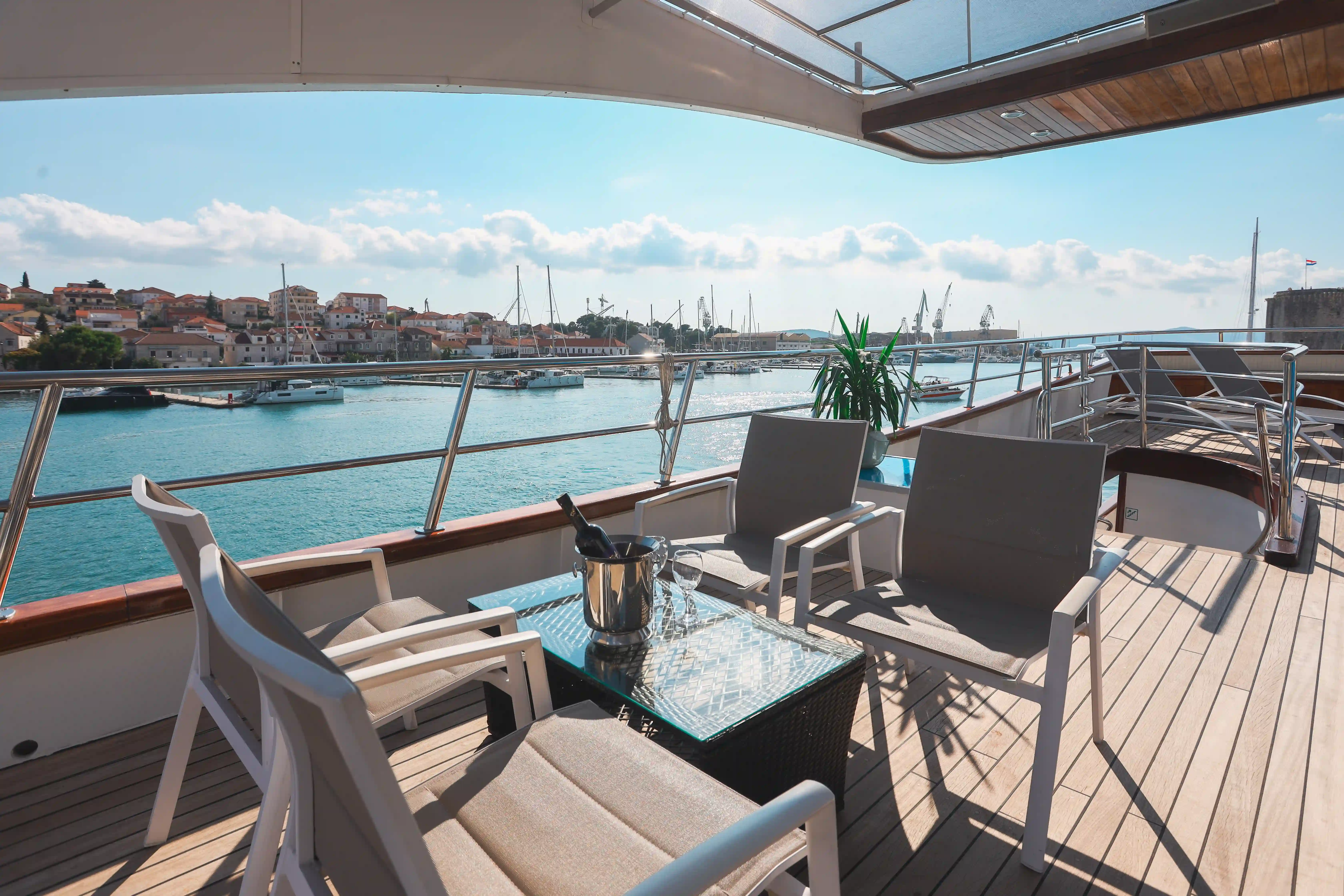Sonnendeck eines Kreuzfahrtschiffes mit Liegestühlen und Hafenblick