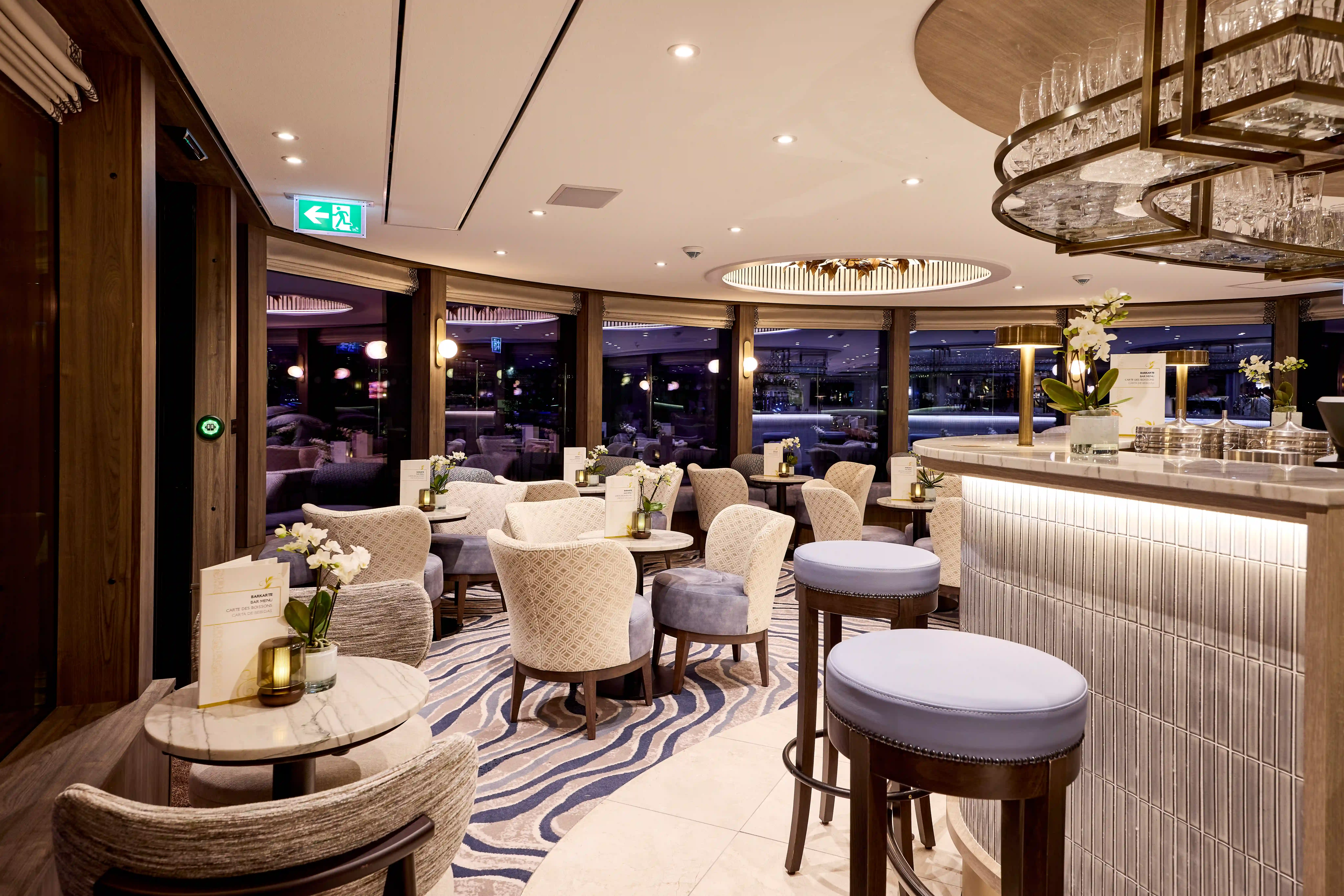 Stilvolle Bar mit Barhockern, gedeckten Tischen, dezenter Beleuchtung und moderner Innenausstattung.