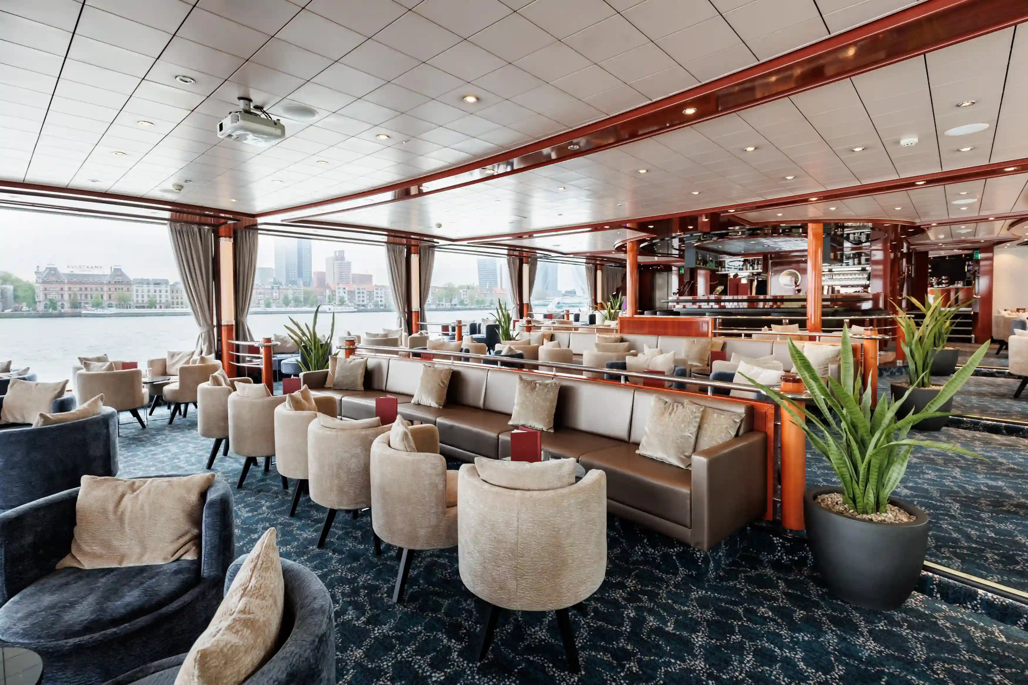 Elegante Panorama-Lounge mit bequemen Sesseln, Barbereich und weitem Ausblick auf die vorbeiziehende Landschaft
