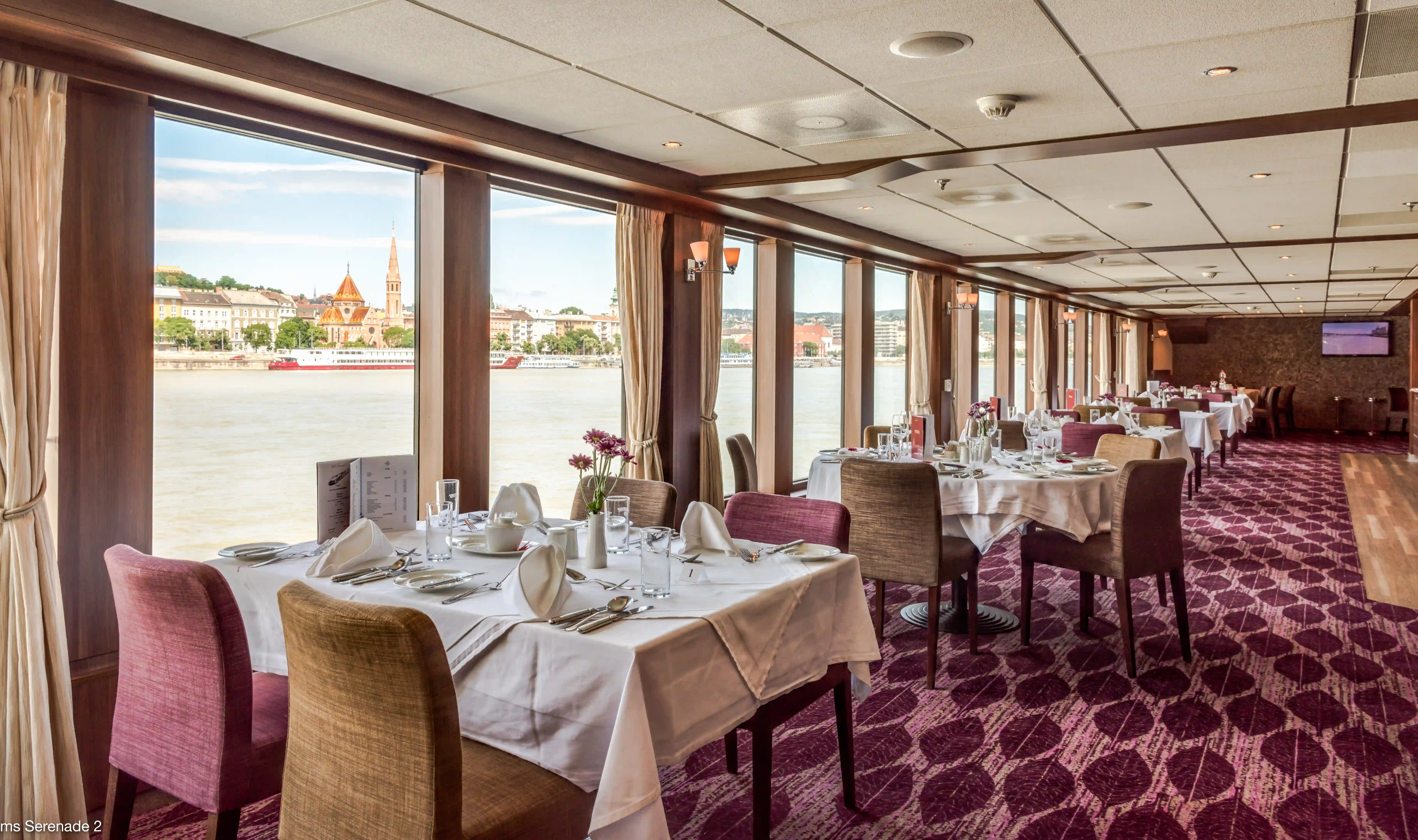 Restaurant raffiné à bord avec vue panoramique, tables élégamment dressées et ambiance conviviale
