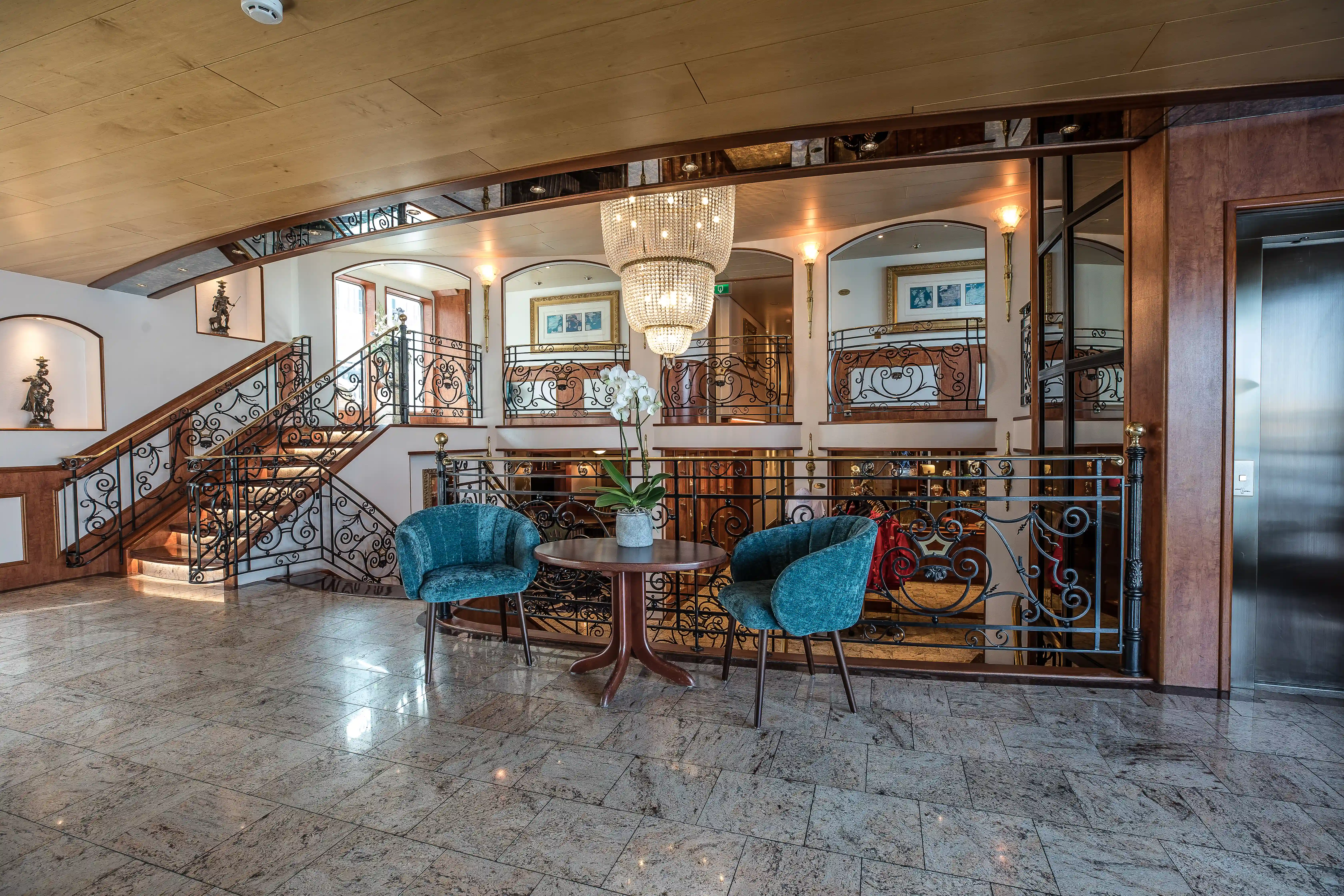 Grosszügiger Innenbereich mit Treppe, Galerie, Kronleuchter und Sitzgruppe