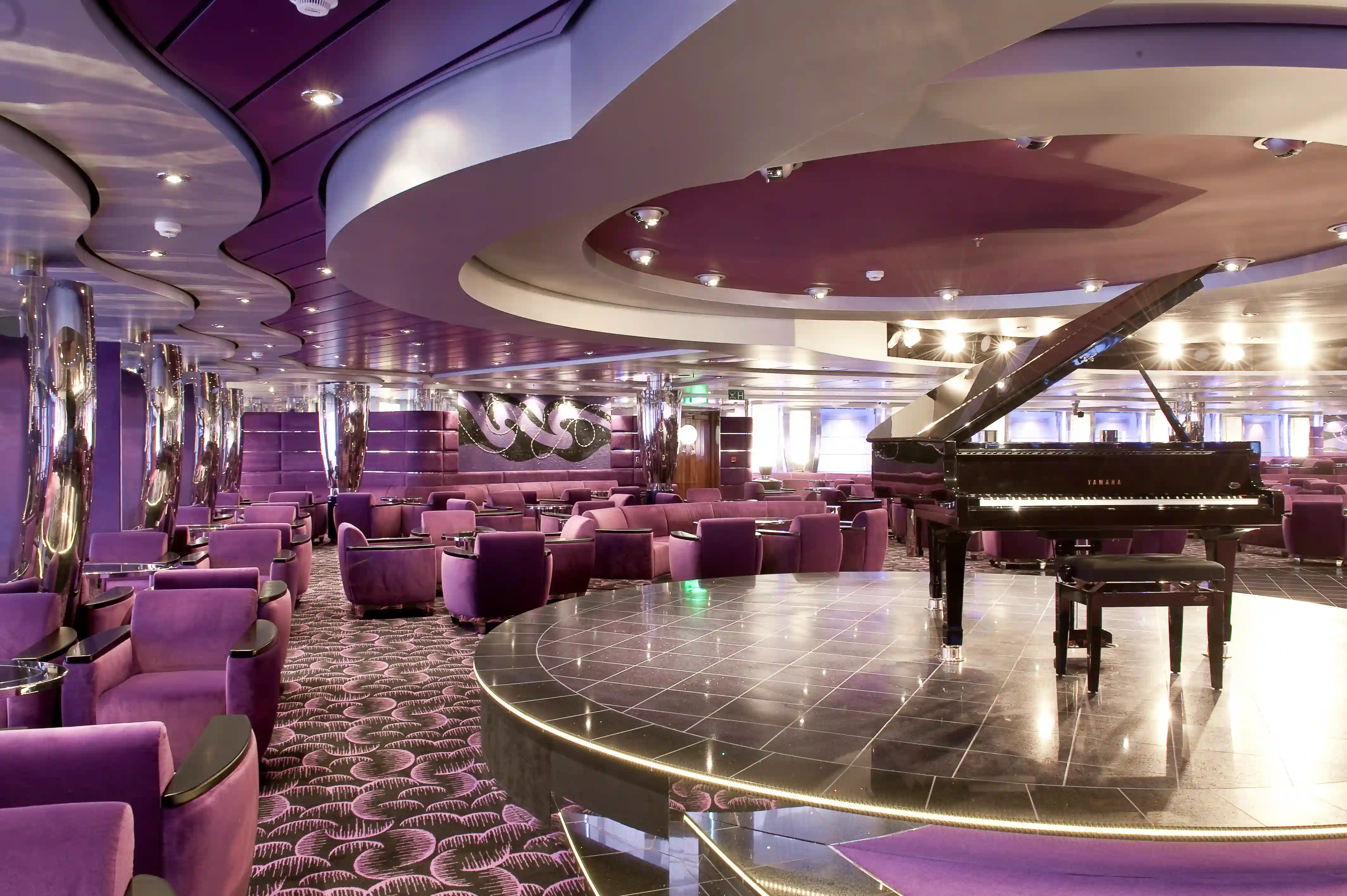 Elegante Innenbar auf der MSC Magnifica mit Piano, Sitzgruppen und stimmungsvoller Beleuchtung.