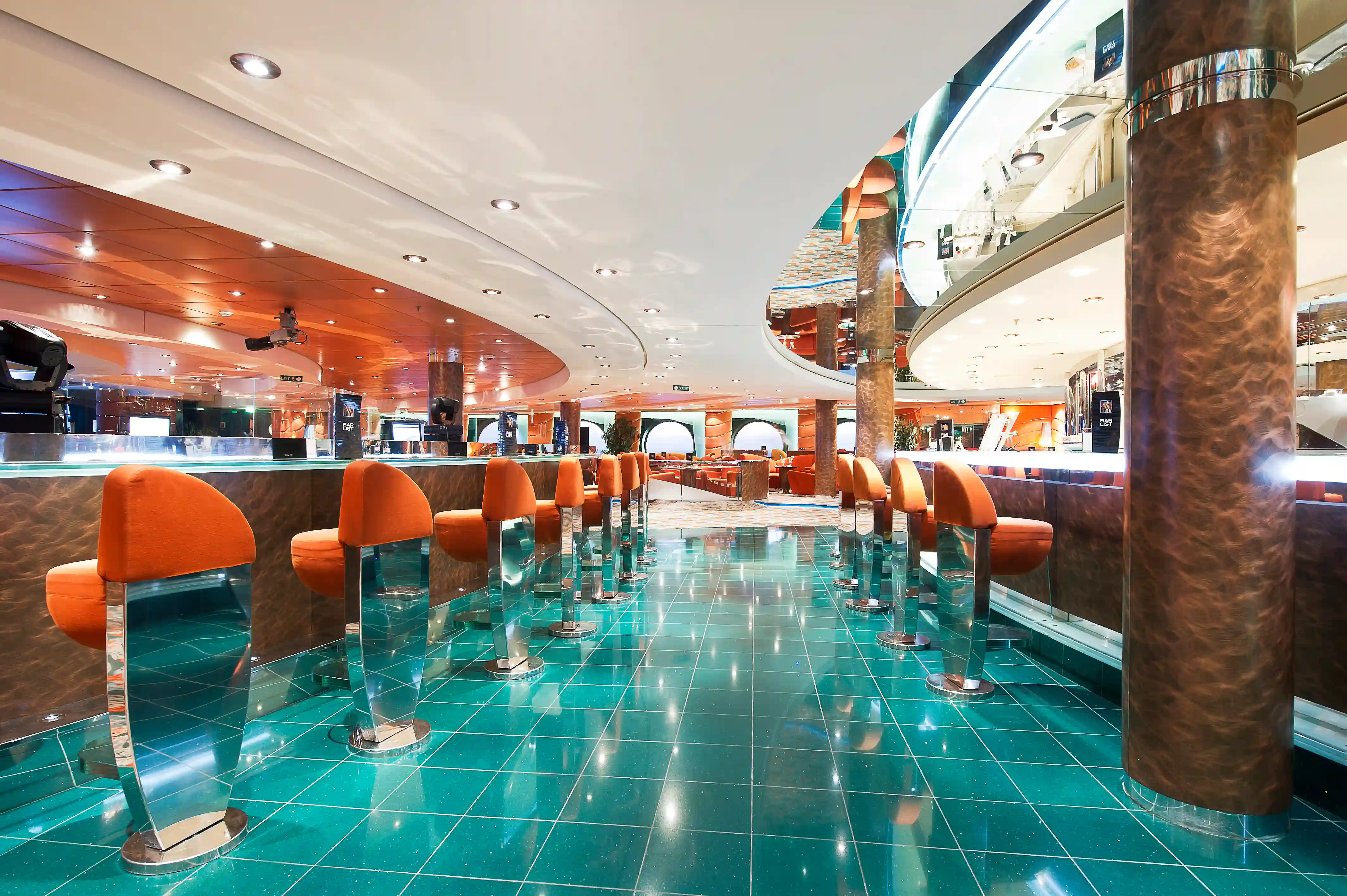 Elegante Bar auf der MSC Musica mit Barhockern, glänzender Theke und stimmungsvoller Beleuchtung.