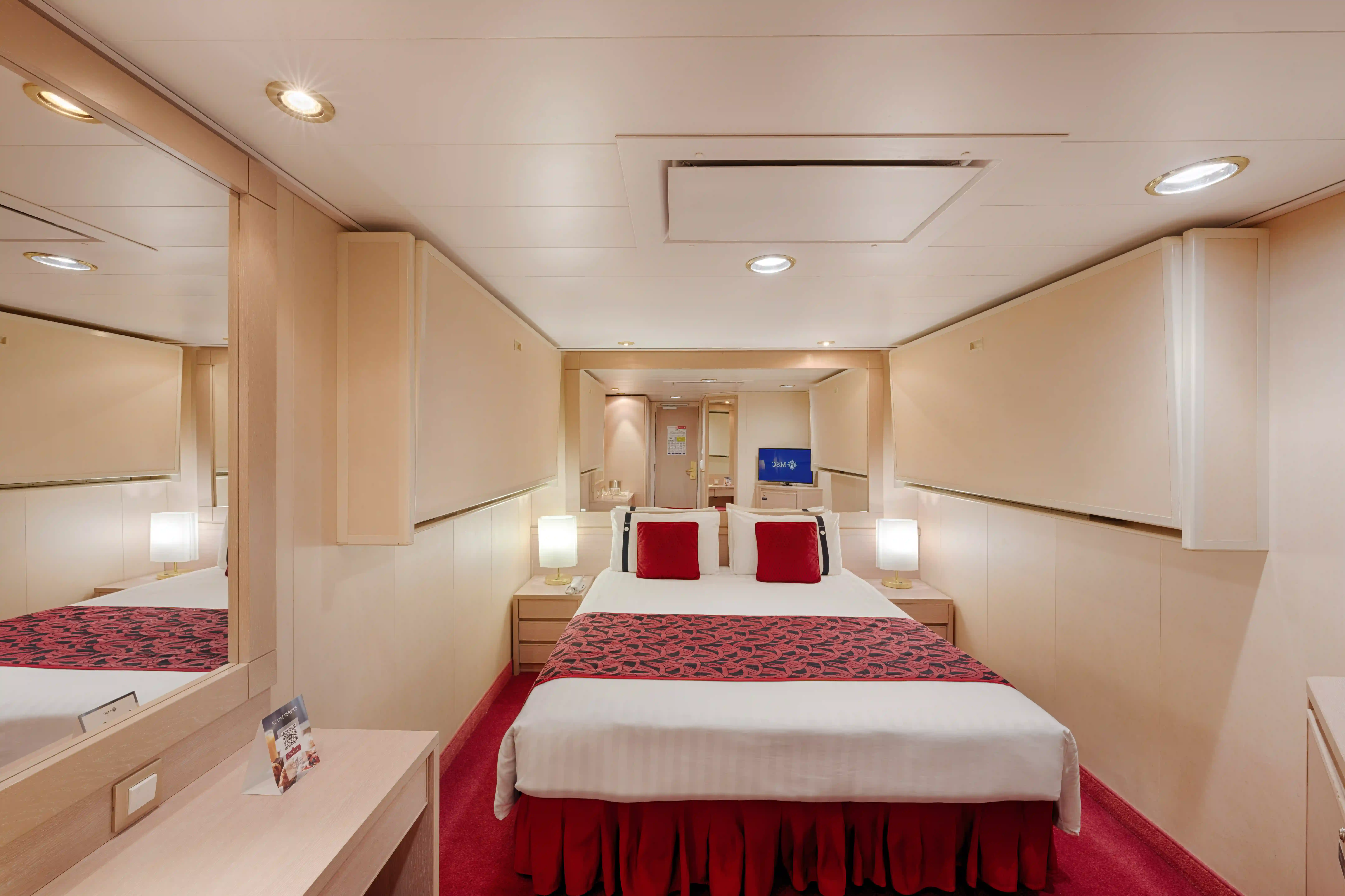 Funktionale Innenkabine der MSC Musica mit Doppelbett, Stauraum und warmem Farbdesign.