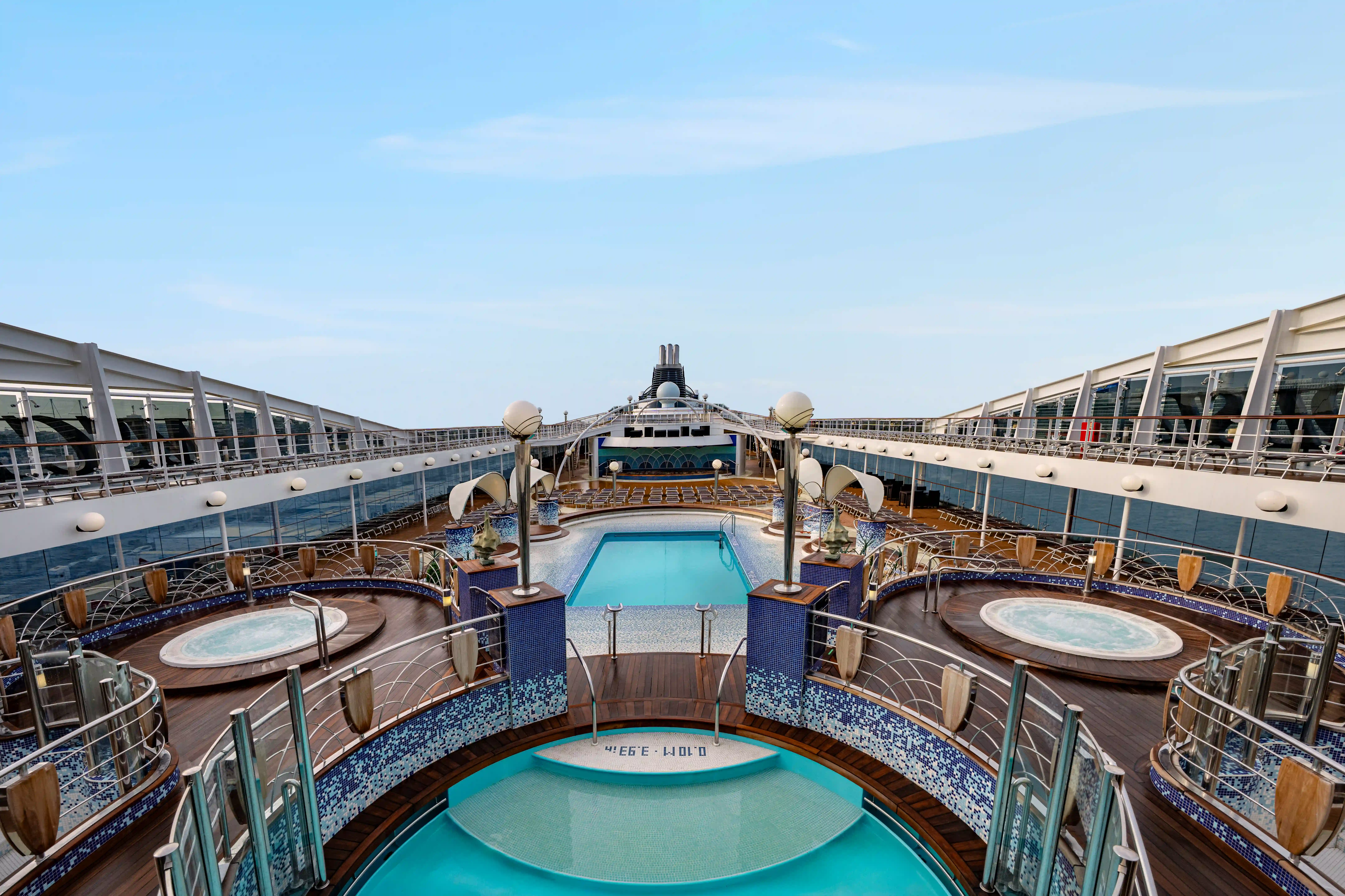 Grosszügige Poollandschaft auf der MSC Poesia mit mehreren Pools, Whirlpools, Liegebereichen und Meerblick