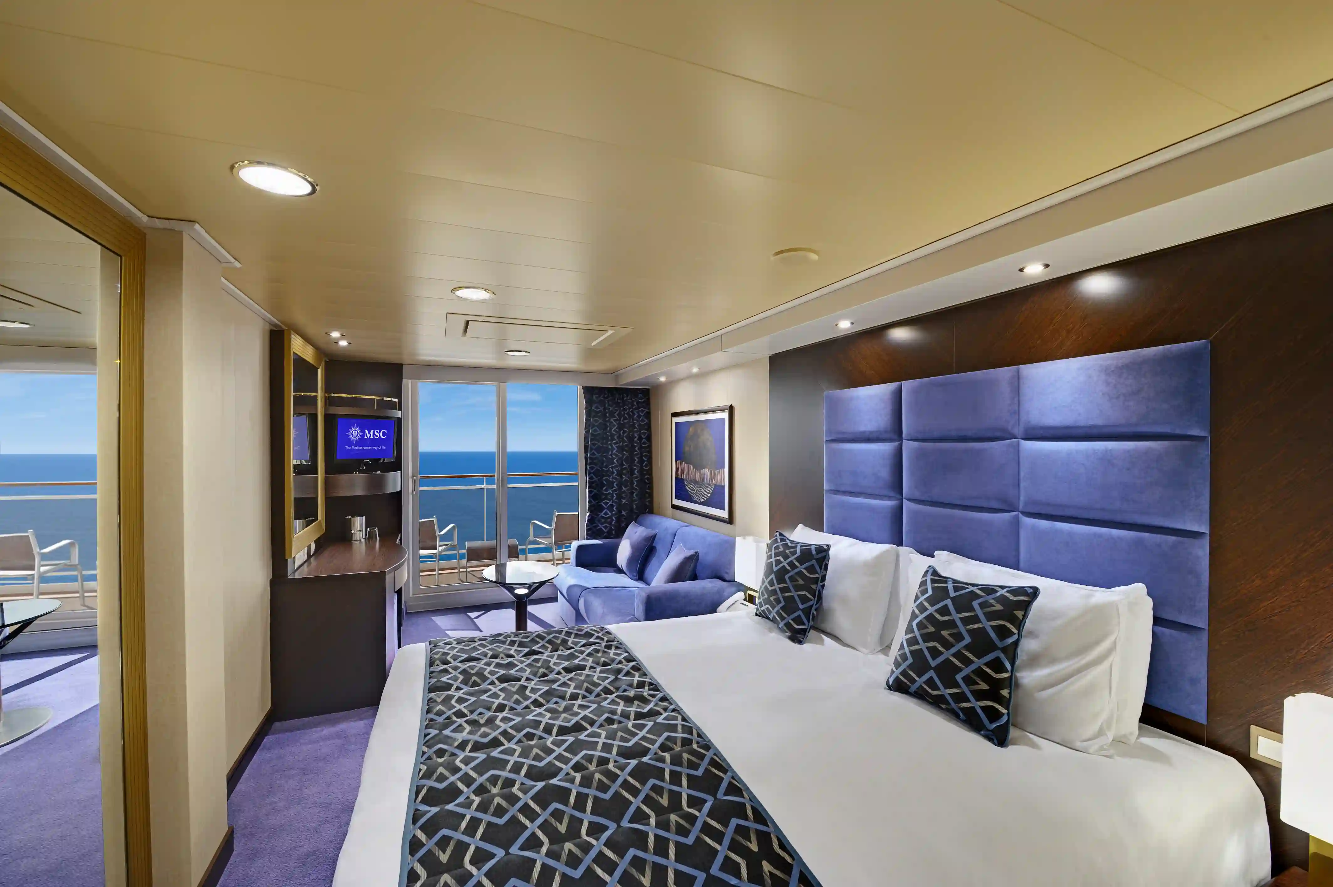 Moderne Balkonkabine der MSC Preziosa mit Doppelbett, Sitzecke und Meerblick