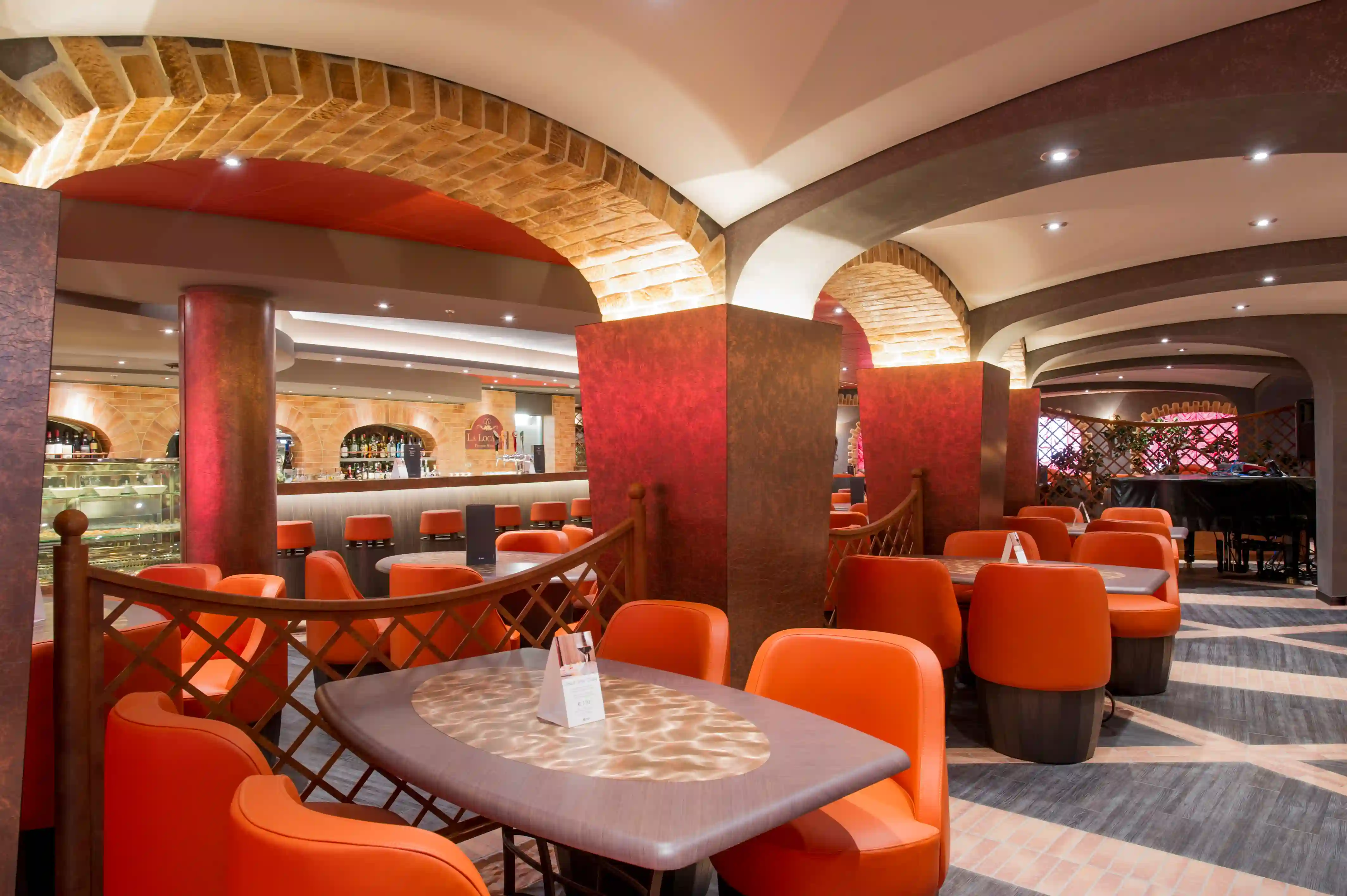 Gemütliche Bar an Bord der MSC Preziosa mit Sitzgruppen, Theke und warmem Licht