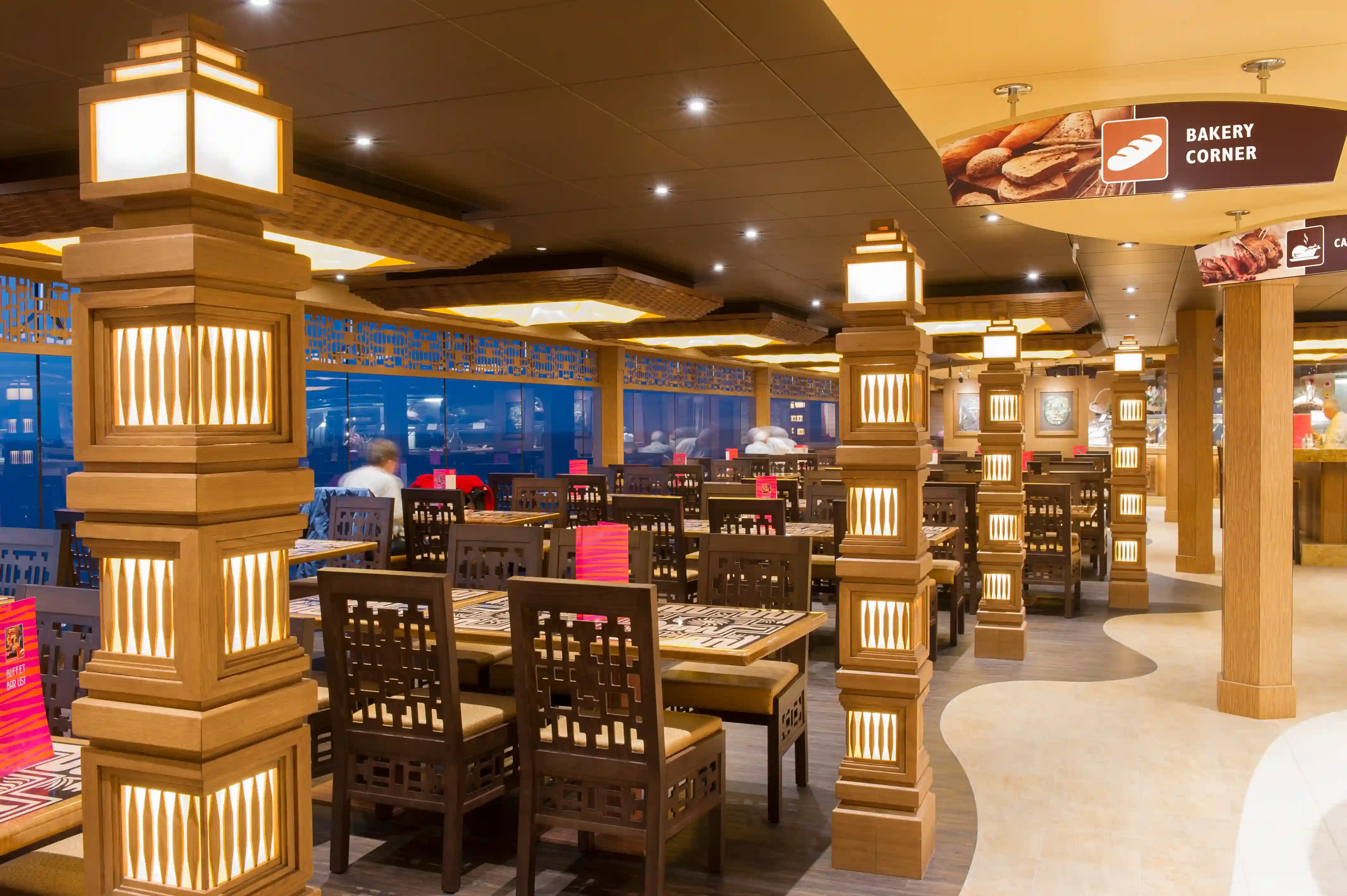 Restaurant der MSC Preziosa mit gedeckten Tischen, warmem Licht und modernem Ambiente