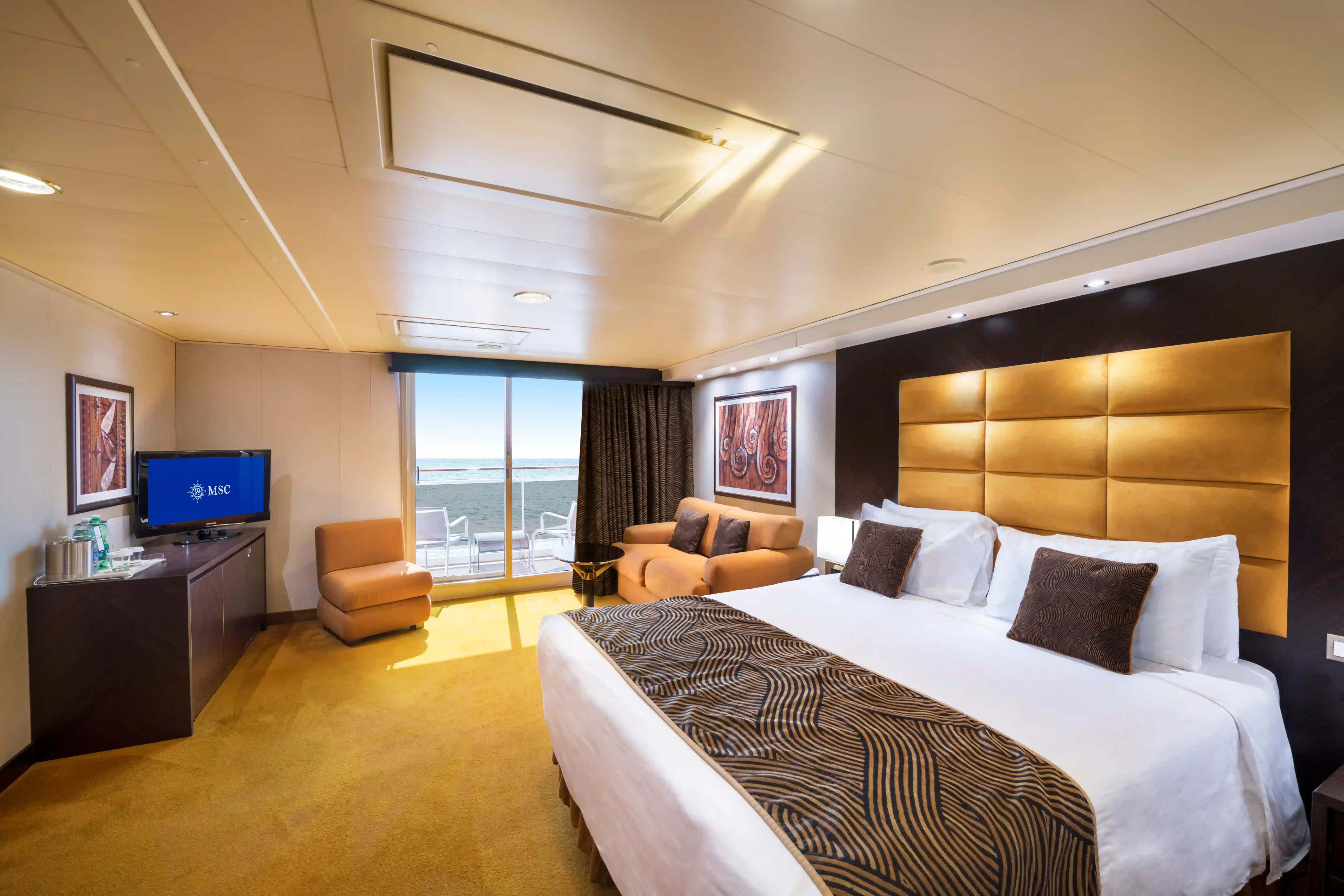 Moderne Balkonkabine der MSC Splendida mit Doppelbett, Sitzecke und Balkon mit Meerblick