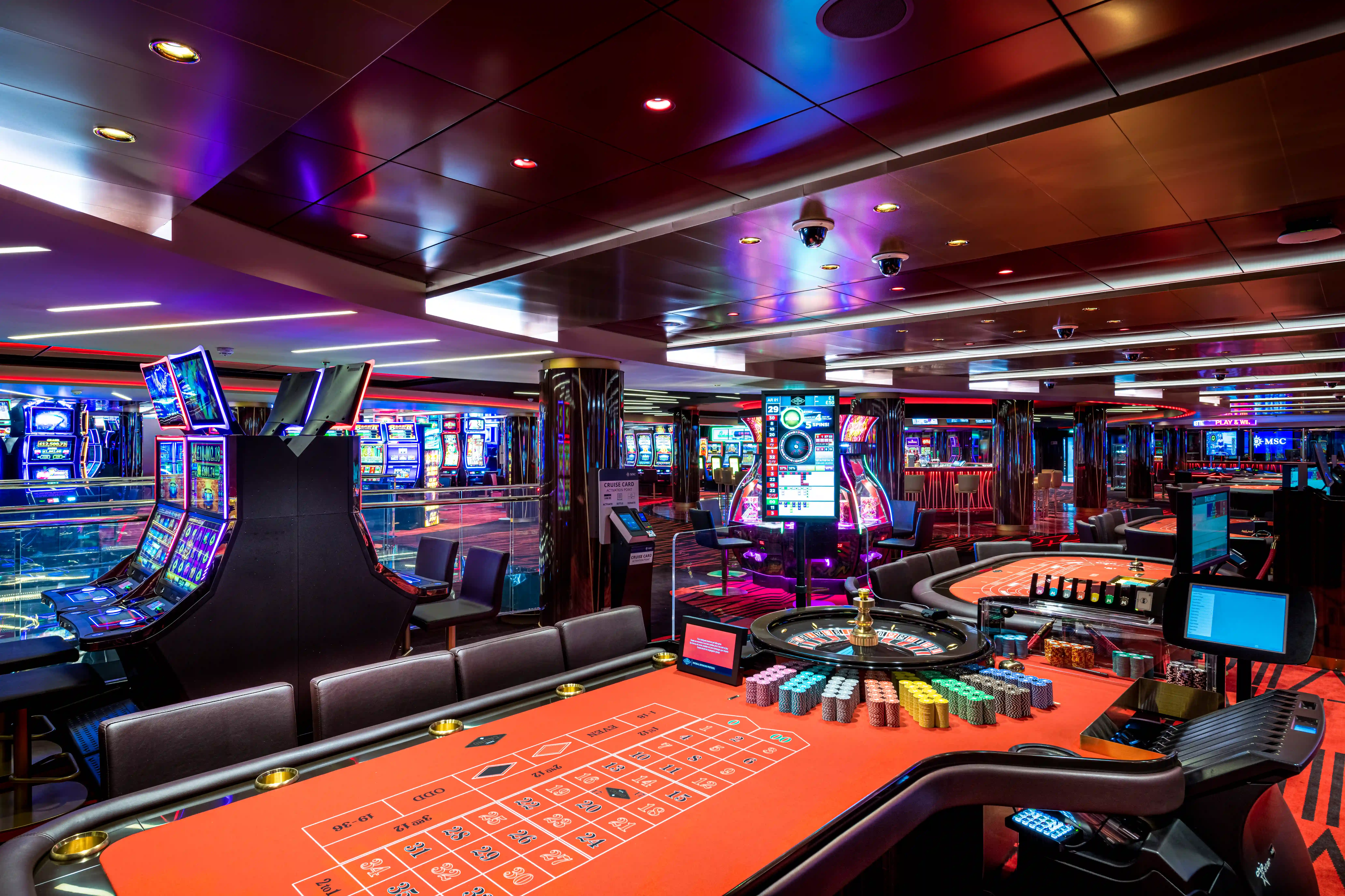 Casino auf der MSC Virtuosa mit Spieltischen, Spielautomaten und farbiger Beleuchtung