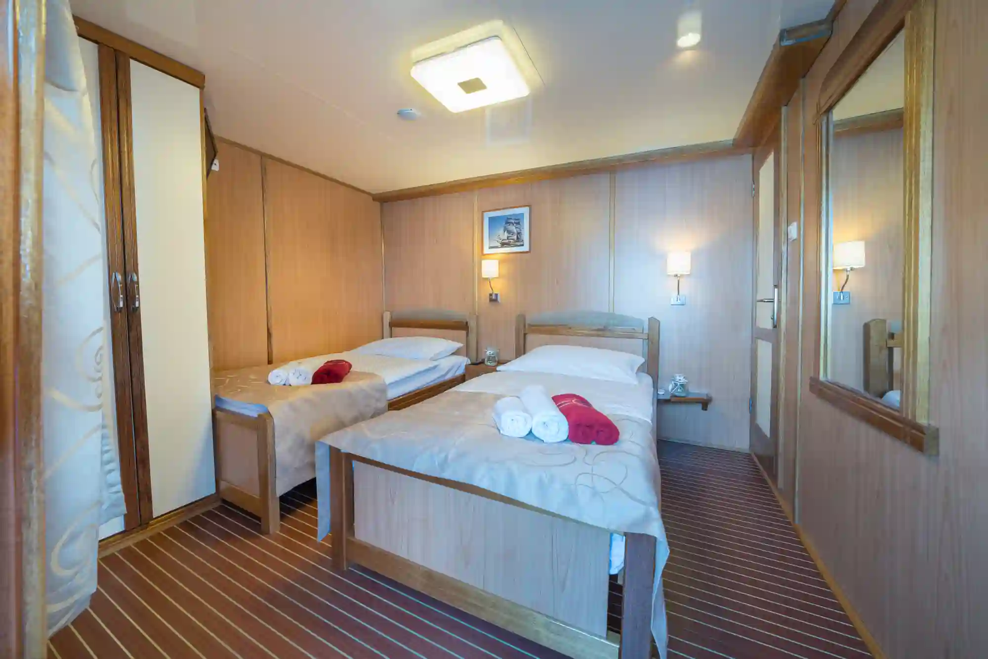 Cabine d’un navire de croisière avec deux lits simples et interieur en bois
