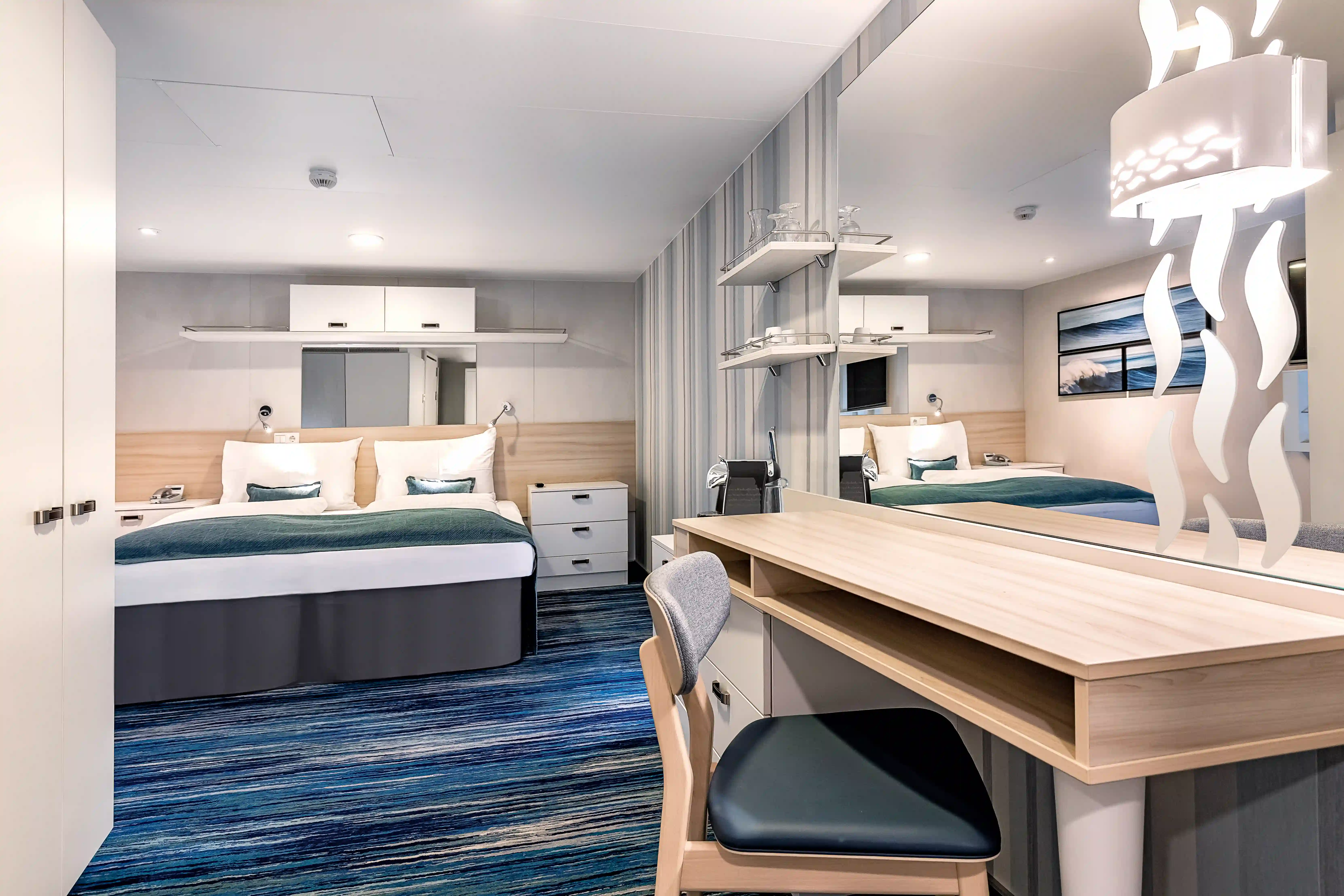 Moderne Innenkabine mit Doppelbett, Schreibtisch, Spiegel und Stauraum