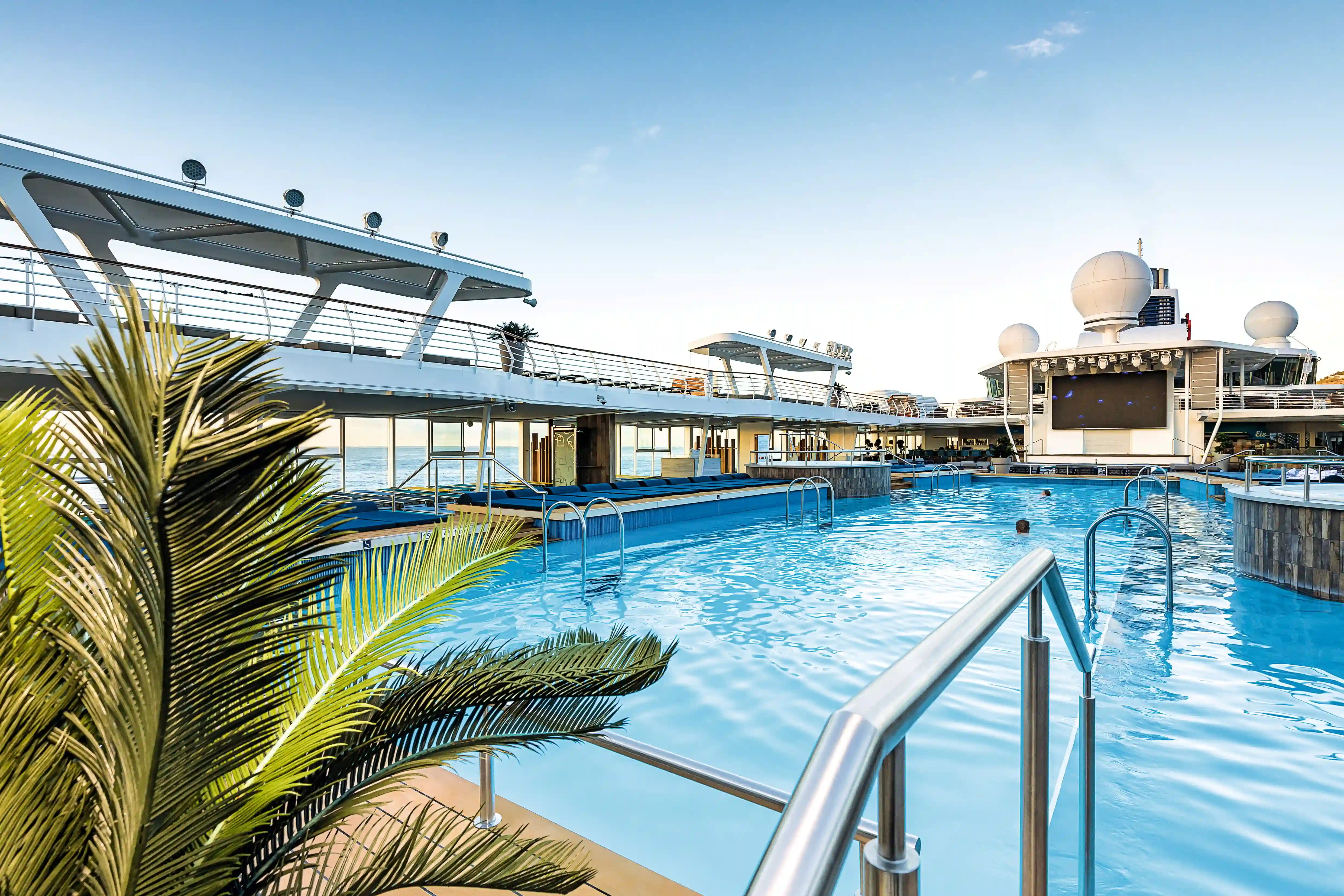 Grosszügiger Aussenpool mit Sonnenliegen, Treppen und Blick auf das offene Meer