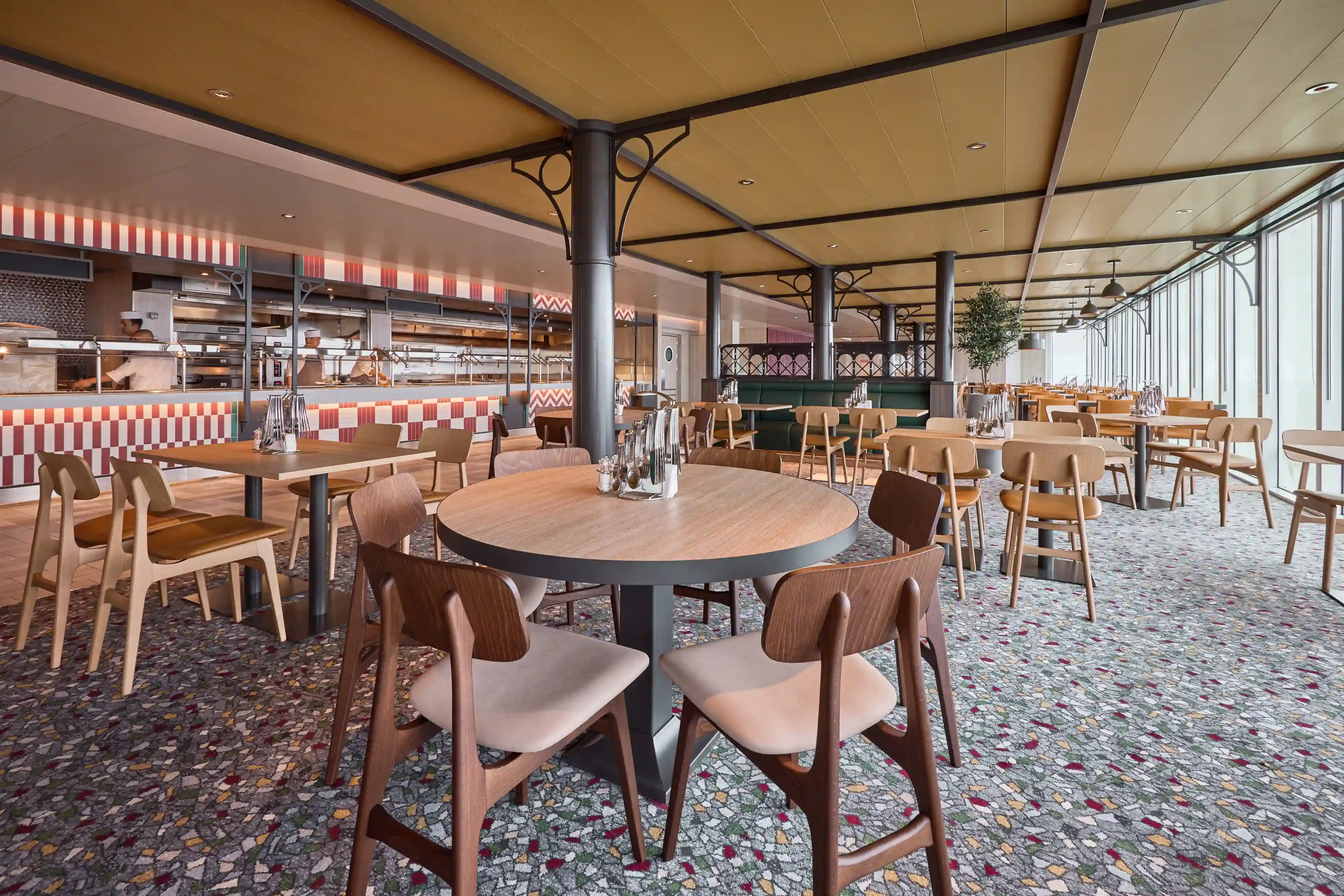 Restaurant mit offenen Sitzplätzen, runden Tischen und offener Küche