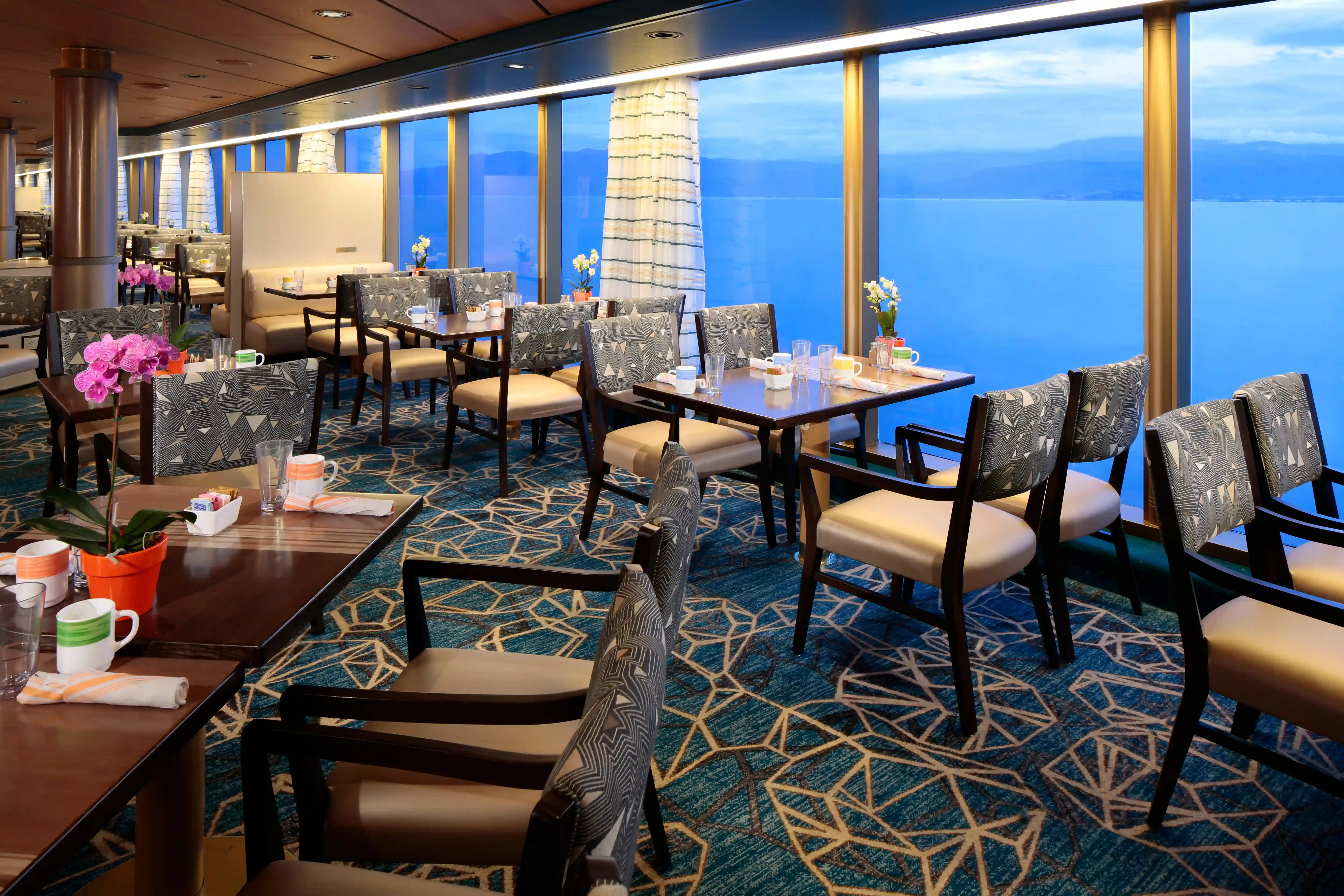 Restaurant an Bord der Westerdam mit gedeckten Tischen und Meerblick