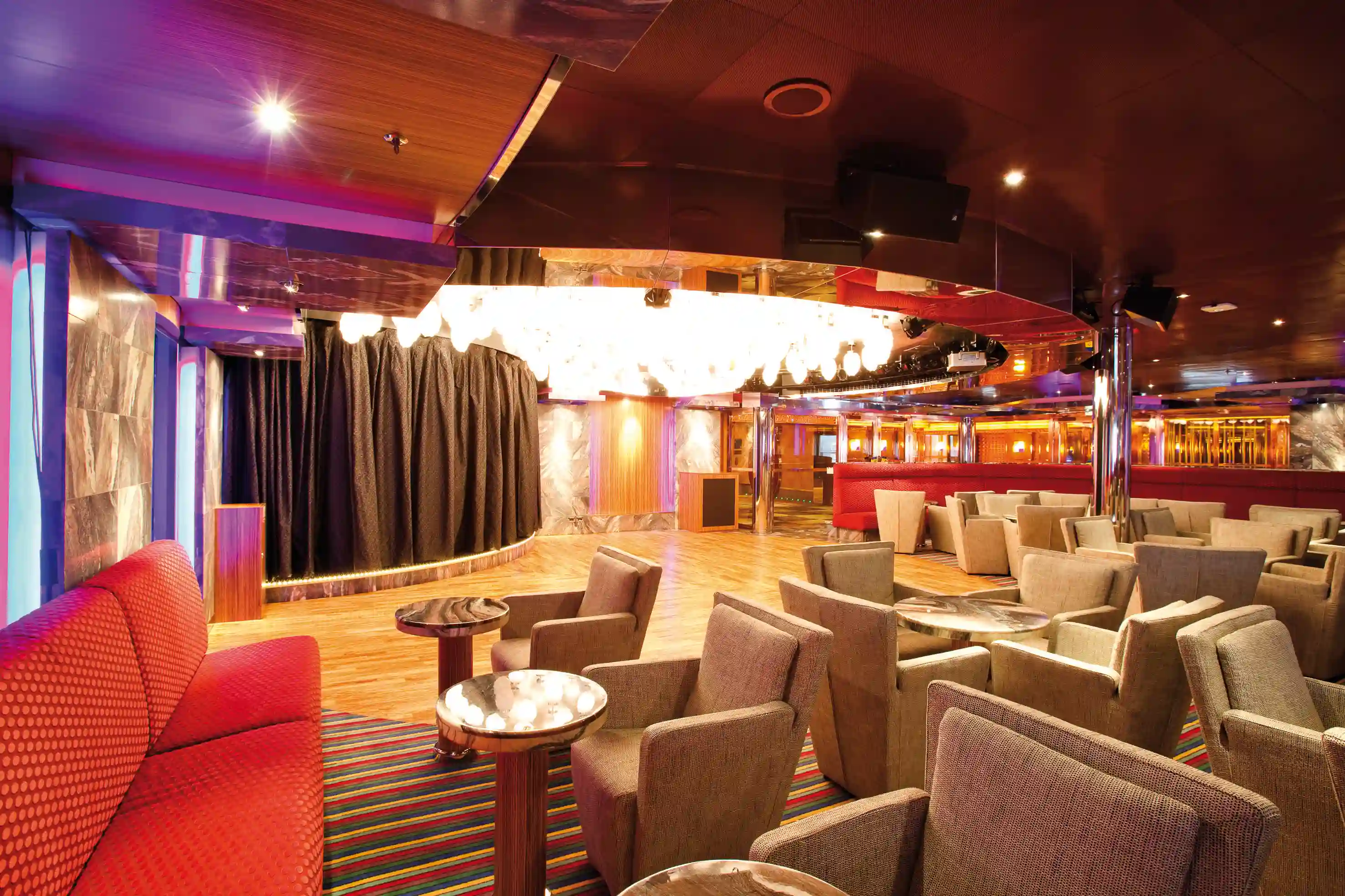 Elegante Lounge mit Bühne, Sesseln und warmem Licht an Bord der Costa Deliziosa