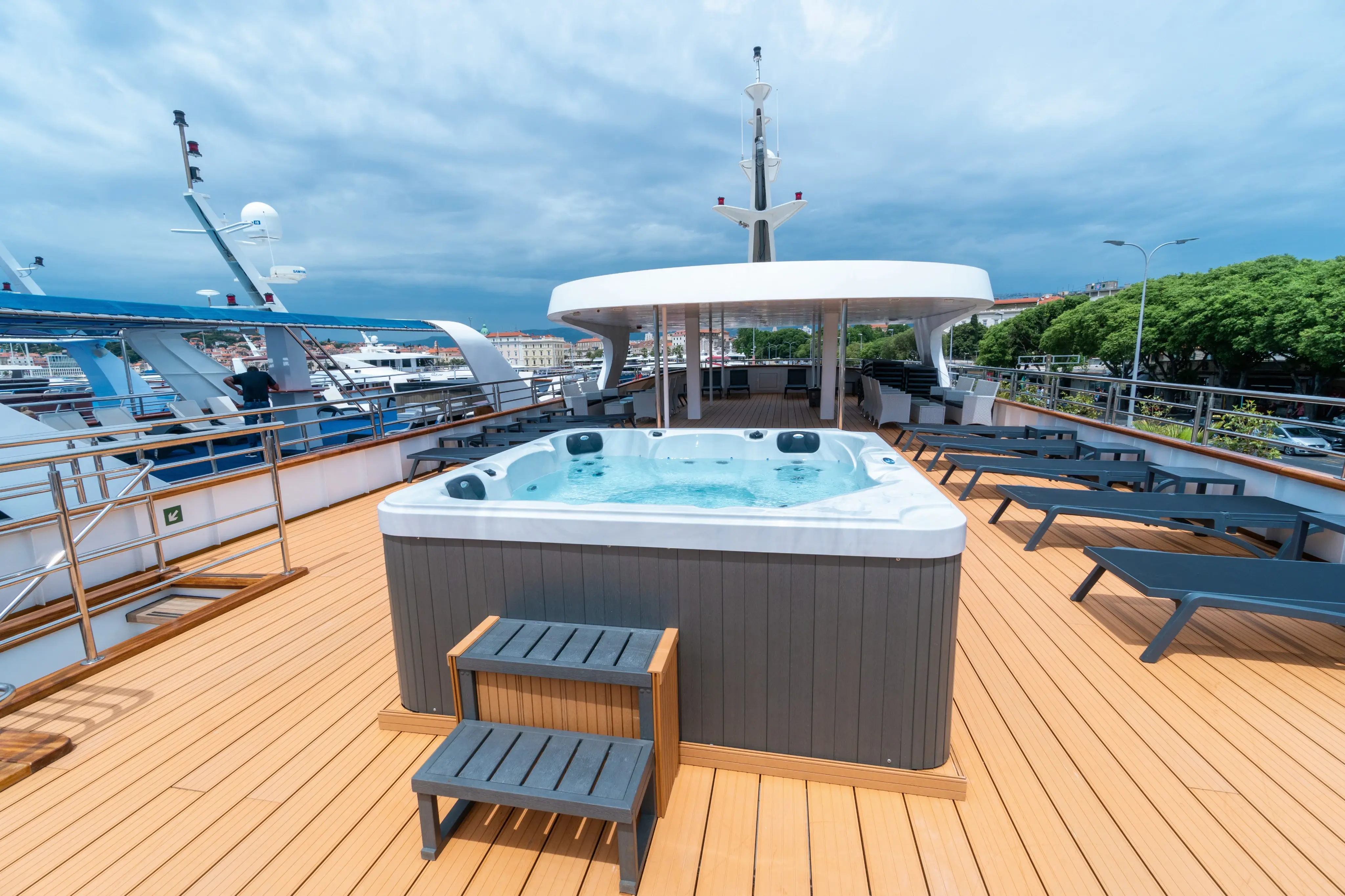 Pont soleil du MS Adriatic Sky avec jacuzzi, chaises longues et espaces de detente sur le pont superieur.