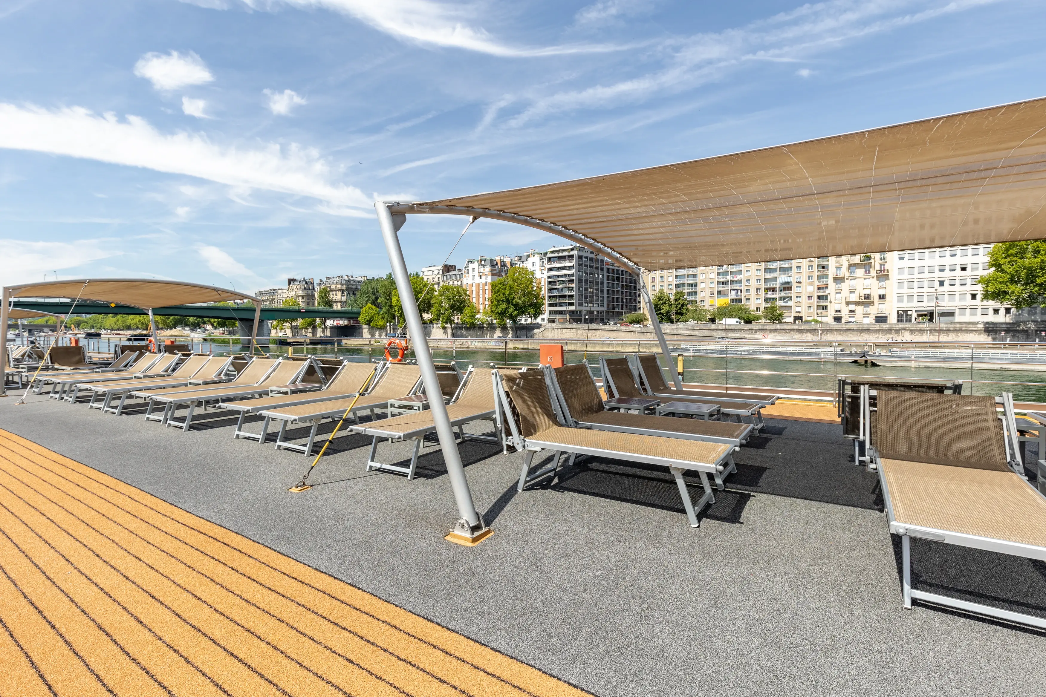Pont soleil du MS Monarch Countess avec chaises longues et voiles d ombrage sous un ciel bleu.