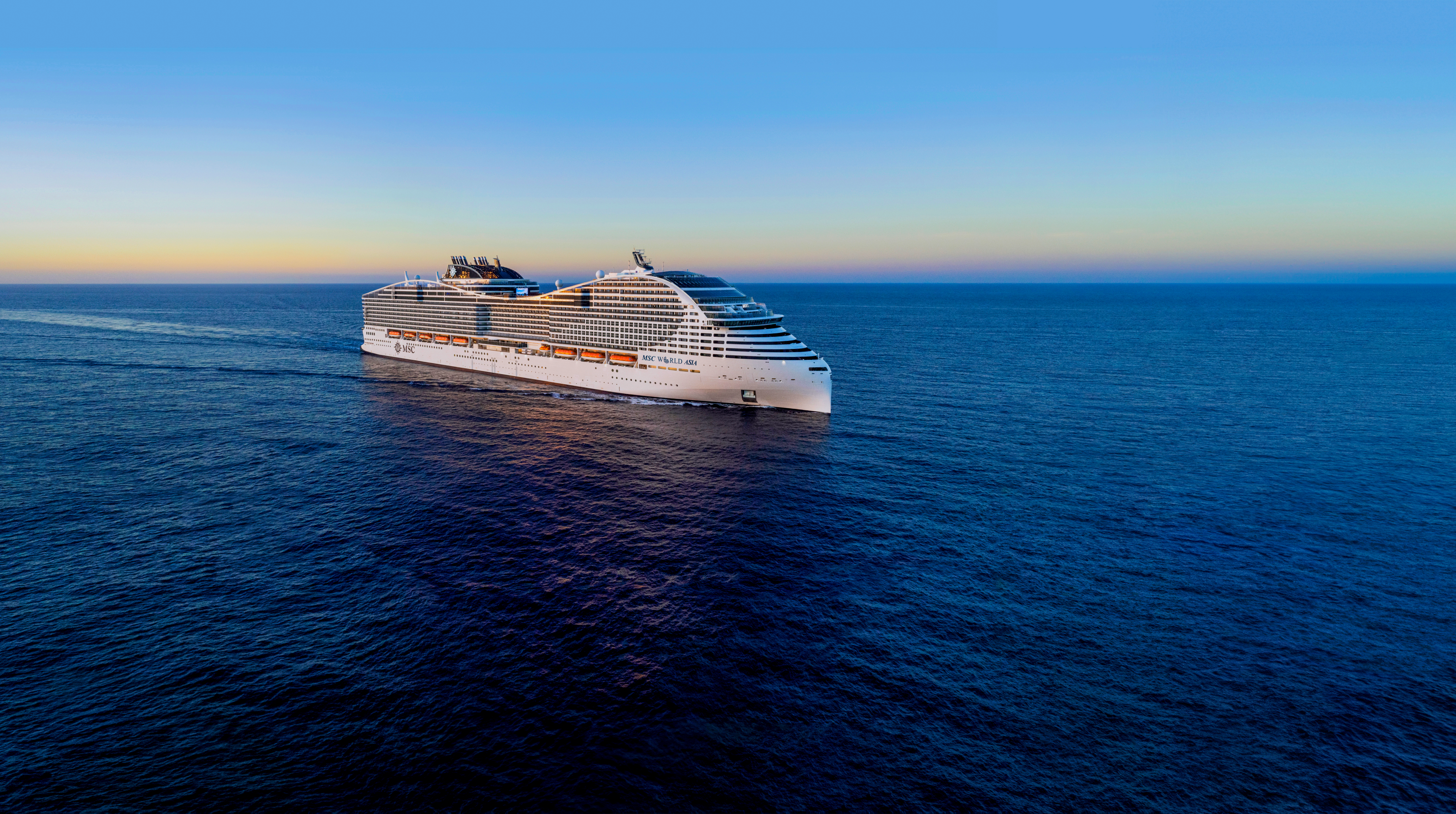 Kreuzfahrtschiff MSC World Asia auf ruhiger See unter klarem Himmel